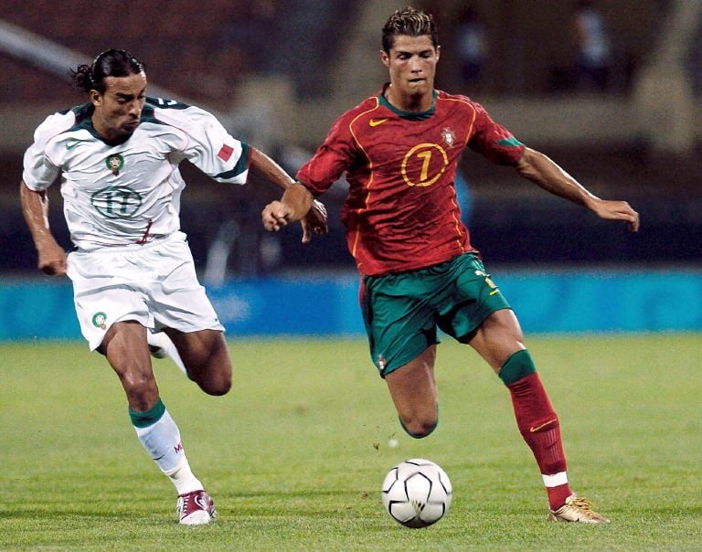 Portugal's Cristiano Ronaldo (R) fights for the ball with Moroccan Otmane El Assas during their group D match at the Pankritio stadium in Heraklion at the 2004 Olympic Games 15 August 2004. AFP PHOTO STEFANOS (Photo by AFP)