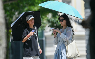 Des gens à l'abri du soleil sous des parapluies