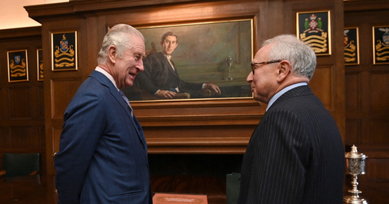 Le roi Charles III de Grande-Bretagne devant un portrait de lui-même en tant que prince de Galles de l'époque.